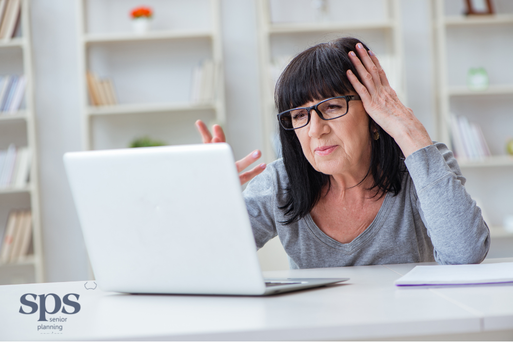 Elderly woman struggling with her laptop, symbolizing the digital challenges many seniors face—highlighting the importance of support through Senior Planning Services.