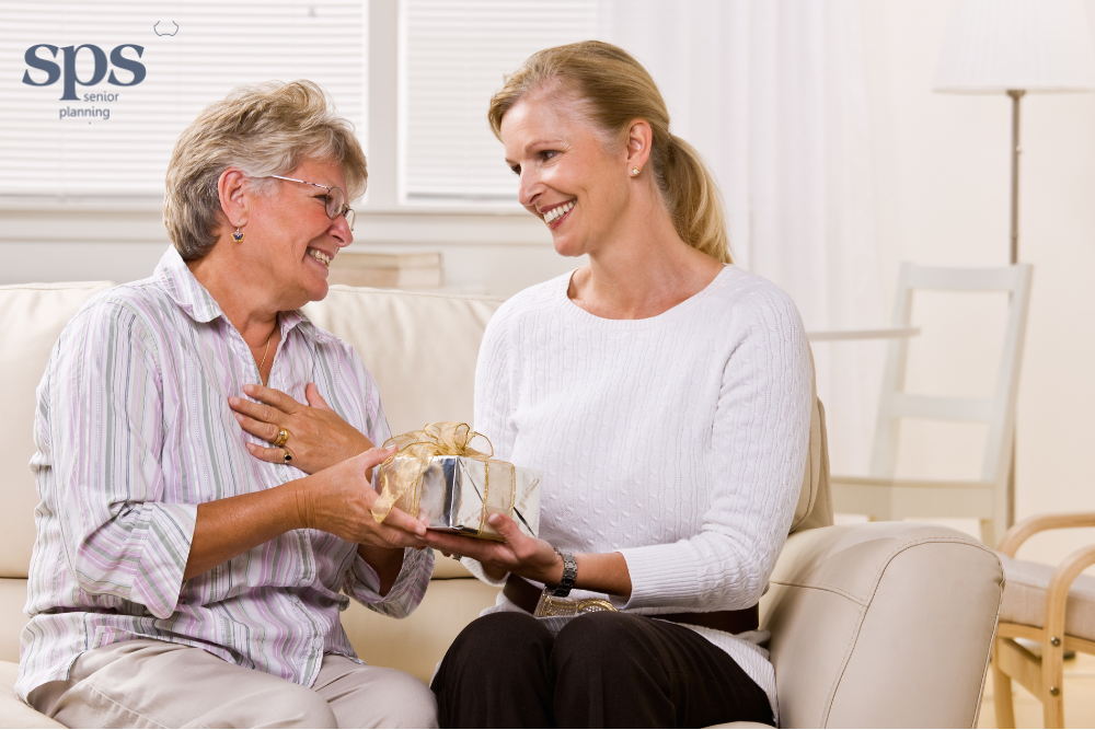 Senior giving a gift to a young person, highlighting the importance of understanding Medicaid gifting rules with guidance from Senior Planning Services.