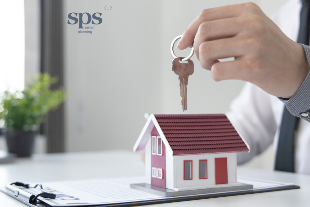 Keys dangling in front of a house, symbolizing a home being sold with the support of senior planning services.