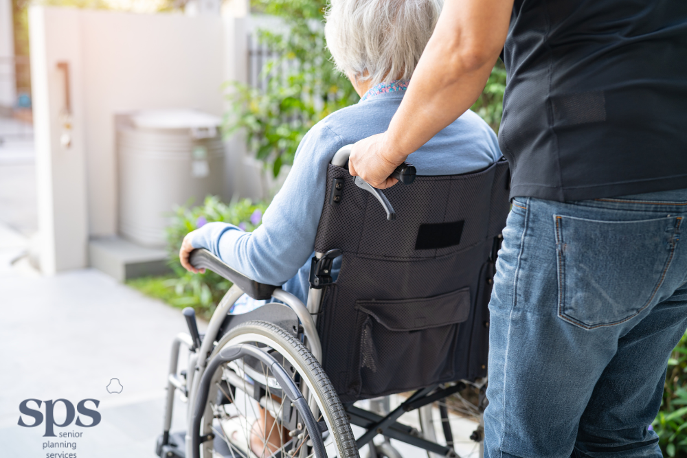 Caregiver wheeling a wheelchair as he provides after hospital care for the elderly - Senior Planning Services
